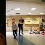In a game demonstrating the speed of light, Highland Elementary first-grader Ava Aguero tries her hardest to outrun light from a flashlight held by Janice Crew of the Pacific Science Center during a &ldquo;space&rdquo; presentation Thursday at the school. (Dan Bates / The Herald)