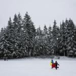 Katelynn Fitzgerald and Tegan Trefey, both 9, race through a snow-covered field at College Place Middle School on Monday in Lynnwood after a storm brought several inches, closing schools throughout the county. (Daniella Beccaria / The Herald)