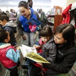 Nicole Amor (right), of Everett, reads with her daughter, Mia, 5, during the grand opening of Mariner Library on 128th Street SW in Everett on Saturday. (Ian Terry / The Herald)