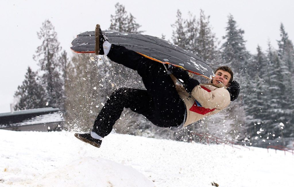 Jalen Velasquez, a junior at Stanwood High School, gets airborne after hitting a jump while sledding at the school on Monday. (Andy Bronson / The Herald)