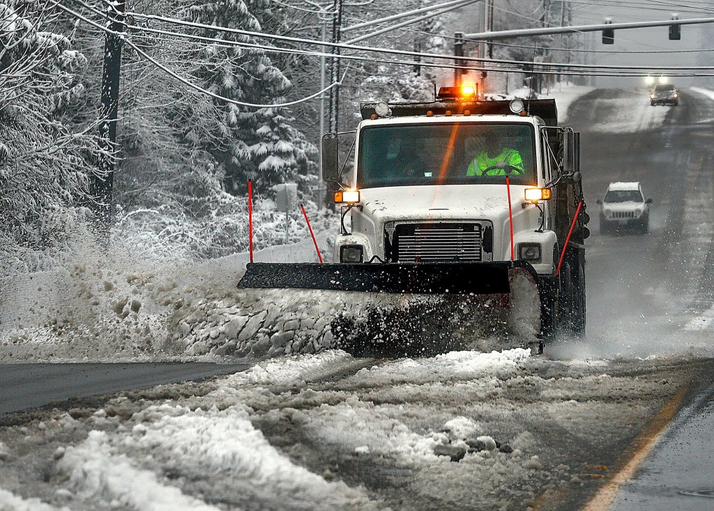 Snow plows, including this one on 20th Street SE between Everett and Lake Stevens, were clearing snow and slush from as many streets as possible before temperatures dropped again Monday night. (Dan Bates / The Herald)