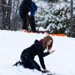 Lexi Powell, 15, uses her cellphone to record herself sledding at Stanwood High School on Monday. (Andy Bronson / The Herald)