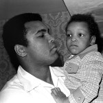 In this April 15, 1975 photo, Heavyweight boxing champion Muhammad Ali, and Little Muhammad Ali, his 2½-year-old son, arrive at Miami Beach, Florida. (AP Photo/File)