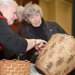 Robin K. Wright, at left, Burke Museum curator of Native American art, examines a visitor&rsquo;s basket at a past Artifact ID Day. Photo by Jack Storms