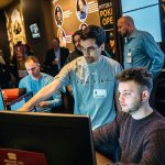 Computer science Ph.D student Noam Brown (center) helps professional poker player, Daniel McAulay, get started during the &ldquo;Brains Vs. Artificial Intelligence: Upping the Ante&rdquo; rematch at Rivers Casino on the North Shore in Pittsburgh on Wednesday. (Andrew Rush/Pittsburgh Post-Gazette)