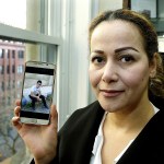 Reema Duhman poses for a photo Wednesday, Feb. 1, in the offices of the Northwest Immigrant Rights Project in Seattle with a photo of her son displayed on her phone. (AP Photo/Ted S. Warren)
