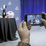 In this Feb. 1 photo, an attendee snaps a photo of the Vince Lombardi Trophy and team helmets during NFL Commissioner Roger Goodell&rsquo;s news conference for Super Bowl 51, in Houston. (Curtis Compton/Atlanta Journal-Constitution via AP, File)
