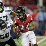 Falcons running back Devonta Freeman (24) runs by Seahawks defensive end Cliff Avril (56) during the first half of a playoff game Jan. 14 in Atlanta. (AP Photo/David Goldman)