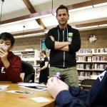 Web comic artist Matt Inman, known for his website The Oatmeal, chats with Dustin Berelson (right), 13, and Howard Dhav Ruado (left), 13, as they playtest his new game, Bears vs. Babies, at the Arlington Library on Wednesday. (Ian Terry / The Herald)