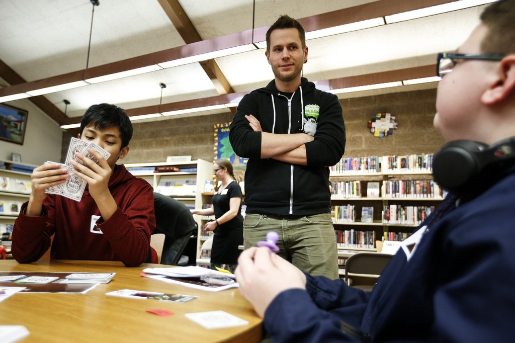 Web comic artist Matt Inman, known for his website The Oatmeal, chats with Dustin Berelson (right), 13, and Howard Dhav Ruado (left), 13, as they playtest his new game, Bears vs. Babies, at the Arlington Library on Wednesday. (Ian Terry / The Herald)