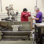 Rob Giger (left) advises fellow student Phil Smith on a class assignment during Everett Community College&rsquo;s manufacturing class at Weston High School on Feb. 1. (Kevin Clark / The Herald)