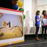 Google employees Laura Nichol (left) and Charlene Tassinari (far right) look on as Isabel Marsh explains her inspiration for a Google Doodle entry during a surprise assembly at Lake Stevens High School on Thursday. (Kevin Clark / The Herald)