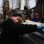 Jarrod Kirkley unloads trash from the back of a pickup truck during a cleanup of an area along the Skykomish River near Monroe on Saturday. Kirkley, an avid fisherman, founded the nonprofit RiverJunky which enlists volunteers to help clean riverbanks across the state. (Ian Terry / The Herald)