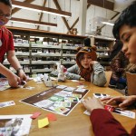 Seanus Selsor (left), 13, Jacob Zapata (center), 11, and Howard Dhave Ruado (right), 13, playtest the new game Bears vs. Babies at the Arlington Library on Wednesday. (Ian Terry / The Herald)
