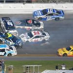 Jimmie Johnson (48), Clint Bowyer (14), Chris Buescher (37), Kevin Harvick (4), D.J. Kennington (96) and Danica Patrick (10) collide in a multi-car wreck between Turns 3 and 4, as Landon Cassill (34) drives past, during the NASCAR Daytona 500 auto race at Daytona International Speedway, Sunday, Feb. 26, in Daytona Beach, Fla. (AP Photo/Phelan M. Ebenhack)