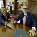 Washington Gov. Jay Inslee looks up after signing an executive order, Thursday, Feb. 23, in his office at the Capitol in Olympia, as general counsel Nick Brown looks on. The order ensures that state workers don&rsquo;t help carry out President Donald Trump&rsquo;s immigration policies. (AP Photo/Ted S. Warren)