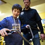Quinn Schmitz, 11, checks out her new tricycle with Jay Hiester, owner of Tim&rsquo;s Bike Shop where the bike was prepared for her, at ATI Physical Therapy in Everett. (Daniella Beccaria / The Herald)