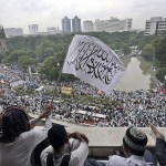 Muslim men wave a flag with Arabic writings which reads &ldquo;There&rsquo;s no God but Allah and Muhammad is His messenger&rdquo; during a rally at Istiqlal Mosque in Jakarta, Indonesia, on Saturday, Feb. 11. Tens of thousands gathered at the national mosque for the mass prayers on Saturday urging Indonesians to vote for Muslims in city and district elections being held across the country next week. (AP Photo/Achmad Ibrahim)