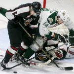 Vancouver&rsquo;s Dylan Plouffe (left) and Everett&rsquo;s Riley Sutter collide on a shot attempt with Vancouver goalie Ryan Kubic defending Saturday night at Xfinity Arena in Everett. (Kevin Clark / The Herald)