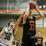 Monroe&rsquo;s Colby Kyle (33) goes up for a shot as Glacier Peak&rsquo;s Bobby Martin (30) reaches for the ball during the Class 4A District 1 boys basketball championship game at Everett Community College on Thursday, Feb. 16. (Ian Terry / The Herald)