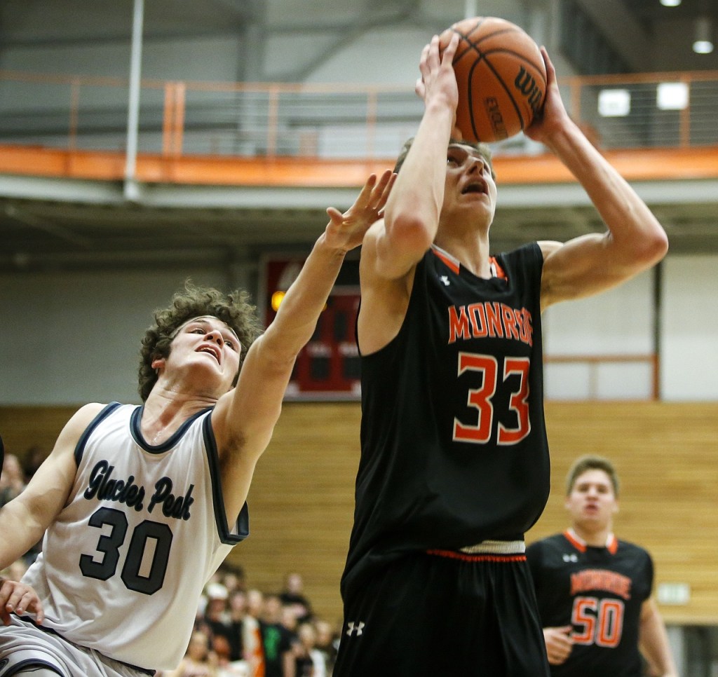 Monroe&rsquo;s Colby Kyle (33) goes up for a shot as Glacier Peak&rsquo;s Bobby Martin (30) reaches for the ball during the Class 4A District 1 boys basketball championship game at Everett Community College on Thursday, Feb. 16. (Ian Terry / The Herald)