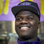 Edmonds-Woodway&rsquo;s Ali Gaye dons a University of Washington hat during a signing day celebration in the school&rsquo;slibrary on Wednesday. (Ian Terry / The Herald)