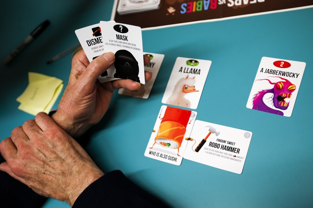 John Cumbow, of Stanwood, lays out his hand while playing the new Bears vs. Babies game at the Arlington Library on Wednesday. (Ian Terry / The Herald)
