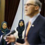 Rokaih Vansot (left), a member of the Washington state chapter of the Council on American-Islamic Relations, stands with Aishah Bomani (center), the principal of Seattle&rsquo;s Makkah Islamic School, as they listen to Washington Gov. Jay Inslee talk to reporters, Thursday, Feb. 23, at the Capitol in Olympia after Inslee signed an executive order to ensure that state workers don&rsquo;t help carry out President Donald Trump&rsquo;s immigration policies. (AP Photo/Ted S. Warren)