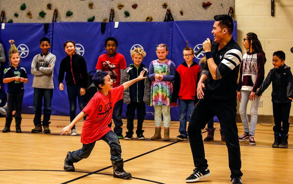 Emerson Elementary School&rsquo;s Adam Thompson demonstrates his skills for professional dancer Jerome Aparis following breakdance lessons that Aparis gave to a group of students. (Dan Bates / The Herald)