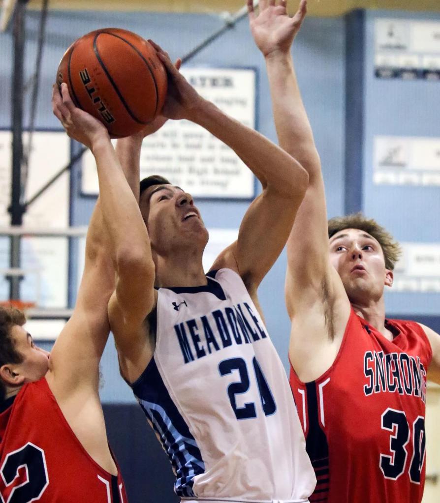 Meadowdale&rsquo;s Daniel Barhoum (center) attempts a shot through the defense of Snohomish&rsquo;s Seth Cavin (left) and Kole Bride (right) during a 3A district play-in game Feb. 10, 2017, at Meadowdale High School in Lynnwood. The Mavericks won 66-54. (Kevin Clark / The Herald)