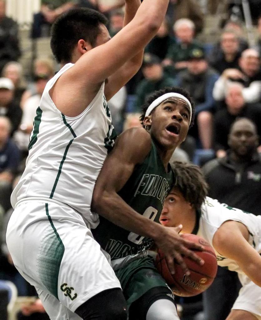 Edmonds-Woodway&rsquo;s Uchenna Acholonu looks to the basket with Shorecrest&rsquo;s Steven Lin (left) and Malcolm Rosier-Butler looking on during a state regional playoff game Feb. 25, 2017, at Bothell High School. Shorecrest won 74-63. (Kevin Clark / The Herald)