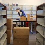 Chelsea Cooper unboxes books at the new Mariner Library in Everett on Feb. 2. The demonstration community library will carry more than 16,000 titles, and will open Saturday. (Kevin Clark / The Herald)