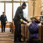 Security guard Rashad Smith wakes a library patron and asks them to leave Wednesday afternoon at the Everett Public Library. (Kevin Clark / The Herald)