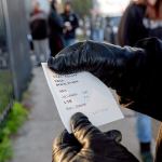 A worker shows a ticket with her assignment for the day. (Mark Boster / Los Angeles Times)