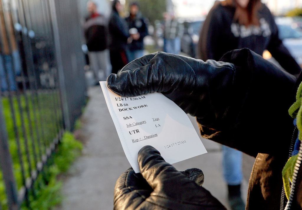 A worker shows a ticket with her assignment for the day. (Mark Boster / Los Angeles Times)