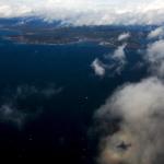 The reflection of a Honeywell test plane is seen against a cloud hovering above the Puget Sound north of Seattle on Thursday, Feb. 9. (Ian Terry / The Herald)