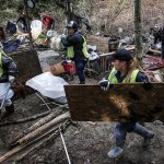 Volunteers remove debris and garbage from a homeless encampment along the Skykomish River near Monroe on Saturday, Feb. 25. Nearly 100 volunteers cleaned out the area in an event organized by Riverjunky and the Snohomish County Sheriff&rsquo;s Office. (Ian Terry / The Herald)