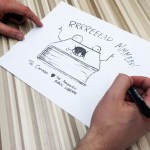 Comic artist Matt Inman creates a drawing for the Arlington Library during a session for the public to playtest his new game, Bears vs. Babies, on Wednesday. (Sara Bruestle / The Herald)