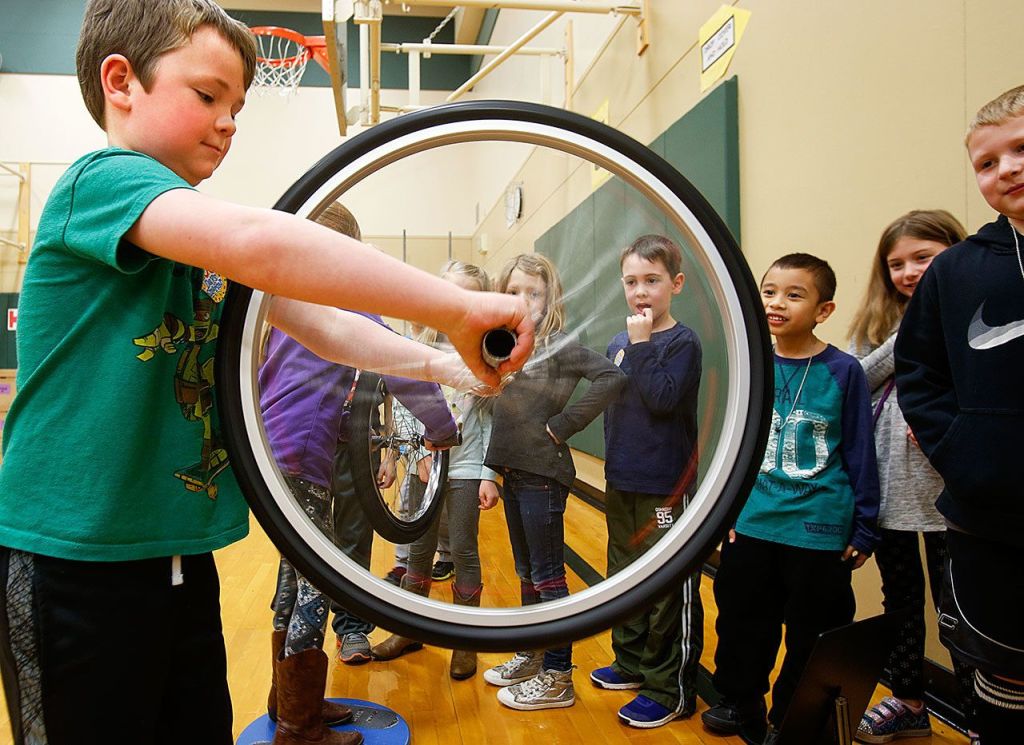 First-grader Sawyer Jensen demonstrates how a gyroscope works for his classmates Thursday during Pacific Science Center&rsquo;s Science on Wheels event at Highland Elementary School in Lake Stevens. (Dan Bates / The Herald)