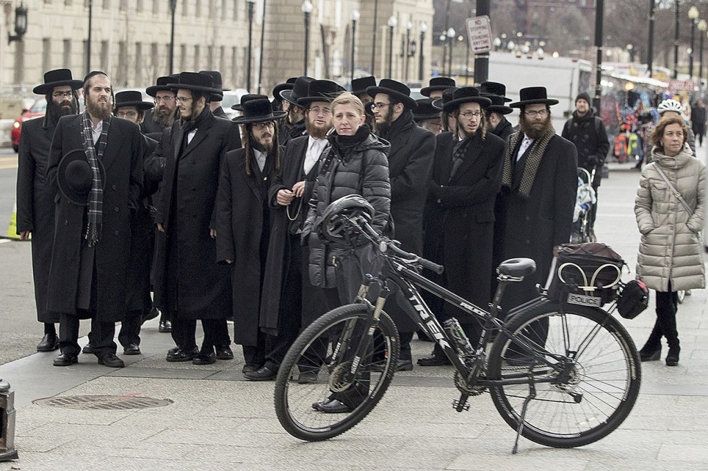 Orthodox Jews stand outside the White House in Washington on Wednesday, Feb. 15, as a motorcade carrying first lady Melania Trump and Sara Netanyahu, wife of Israeli Prime Minister Benjamin Netanyahu, passes them. (AP Photo/Andrew Harnik)