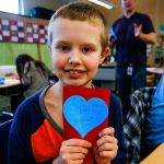 Fourth-grader Kasen Cooley shows off a Valentine&rsquo;s Day card he made Thursday to donate to Valentines for Veterans. (Dan Bates / The Herald)