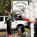 Police officers stand at the entrance to the street leading to Sandy Hook Elementary School in 2012 in Newtown, Connecticut, a day after a shooting where 26 people died. (Olivier Douliery/Abaca Press/TNS)