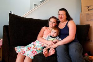 Maria Corcoran and her daughter Ana, 8, hold her 11-month old son, Jimmy, at their new home in Lake Stevens Friday. Her husband Jay Corcoran died on Valentine&rsquo;s Day, just a week after the family moved from Utah to Lake Stevens. (Dan Bates / The Herald)
