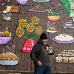 Artist Henry Ward carries his spray paints back to his car after finishing a mural entitled &ldquo;Table of Diversity&rdquo; on the west side of the Everett United Church of Christ. The spray paint and acrylic mural took four days to complete. He volunteered his time in support of the Interfaith Association of Western Washington, which runs a family homeless shelter in Everett. (Andy Bronson / The Herald)