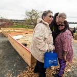 Father Pat Twohy is hugged by Tulalip Tribes Annette Napeahi (left) and Sheryl Fryberg after the dedication of a medicine wheel garden at the Tulalip Health Clinic on Monday, March 20. (Andy Bronson / The Herald)