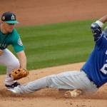 Seattle third baseman Kyle Seager (left) prepares to tag Kansas City&rsquo;s Alcides Escobar (2) during a Cactus League game last week in Peoria, Ariz. Escobar was safe on the play. (AP Photo/Charlie Riedel)