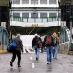 Pedestrians walk onto the Washington ferry Tokitae after cars are loaded for the Mukilteo to Clinton route on Monday. An overhead loading for pedestrians will be included in the city&rsquo;s new $134.7 million ferry terminal. (Andy Bronson / The Herald)