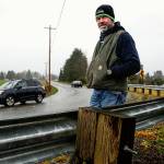 Todd Macomber stands where many a speeding car coming down 100th Street NE used to fly right out onto the Macomber Farm pasture before the county put up guardrails. There are 14 such problem curves on which the county plans to apply a high-friction surface treatment this summer. (Dan Bates / The Herald)