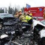 Snohomish District 4 firefighters and medics work to free the driver of one of two vehicles involved in a head-on collision on U.S. 2 north of Snohomish on Saturday. (Doug Ramsey / For The Herald)