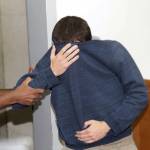 A 19-year-old dual U.S.-Israeli citizen covers his face as he is brought to court in Rishon Lezion, Israel, on Thursday, March 23. (AP Photo/Nir Keidar)